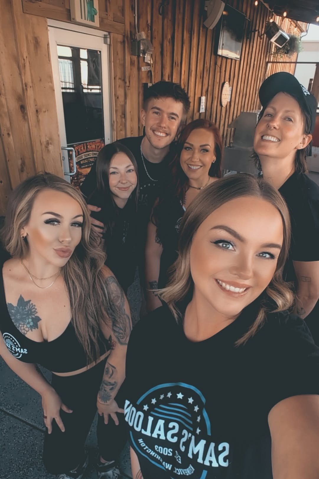 The Sam's Saloon crew smiling together on the patio in their Sam's shirts, Kennewick, WA